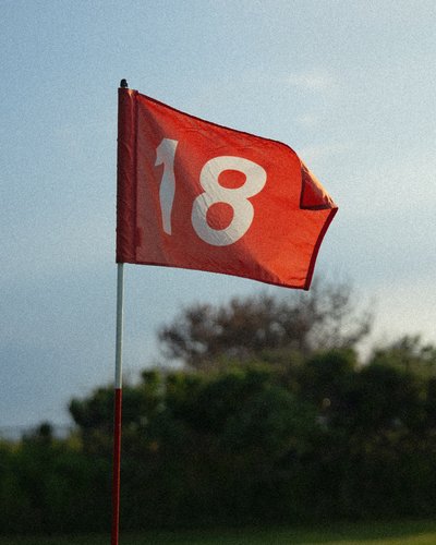 Ihr Golfhotel in Tirol – MOHR life resort Rote Fahne mit der Zahl 18 auf einem Golfplatz