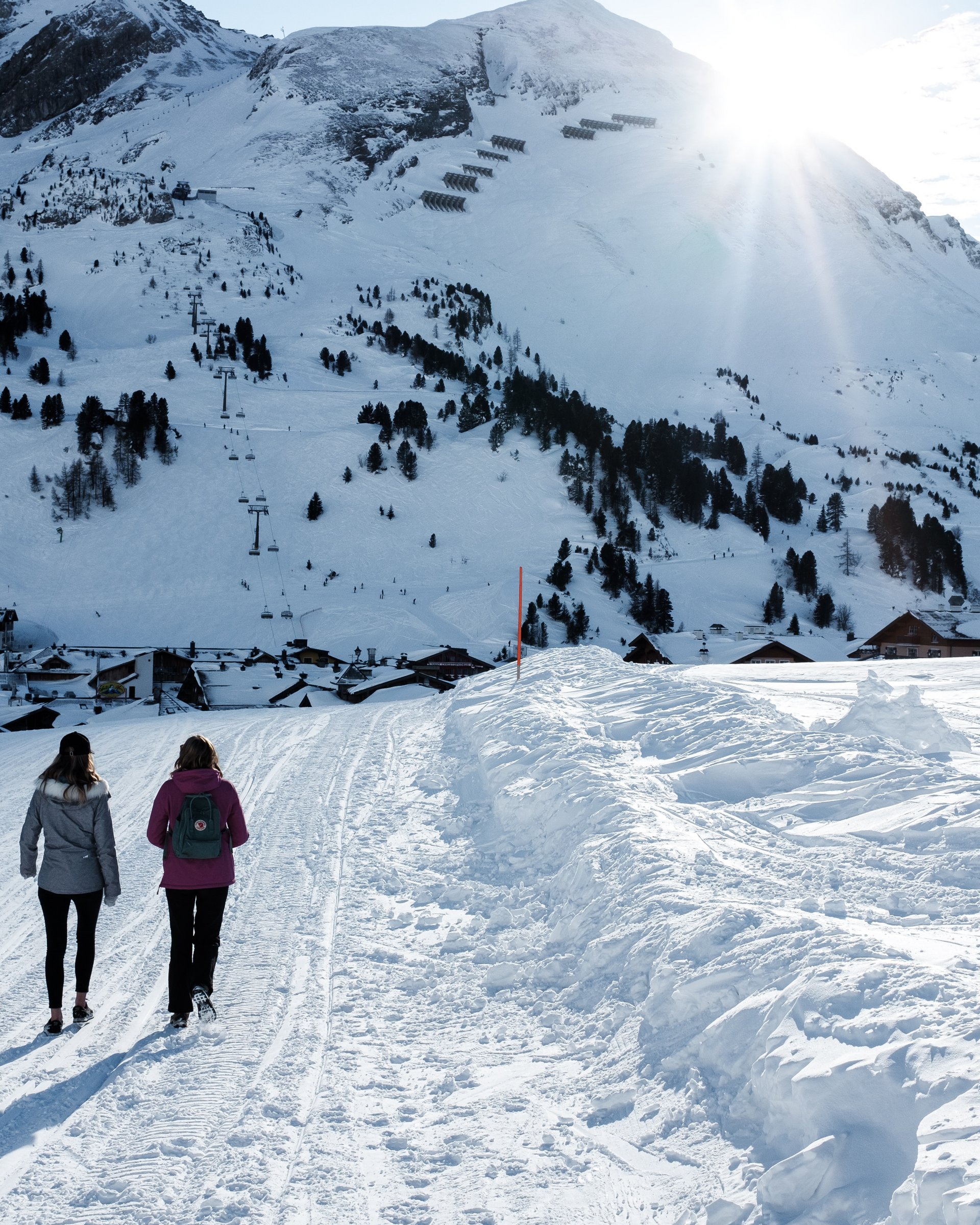 Wunderbares Winterwandern in Lermoos Zwei Personen wandern im Schnee vor schneebedeckten Bergen und Dorf