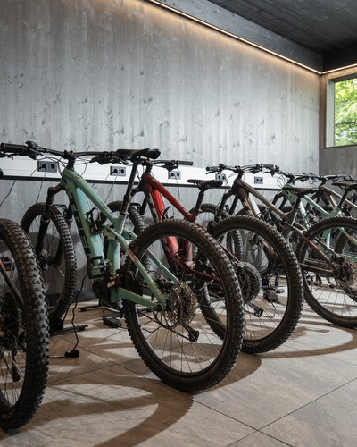 Schwerpunkt Biken in Ihrem Hotel in Lermoos E-Mountainbikes in einer modernen Garage mit großen Fenster und Holzwänden