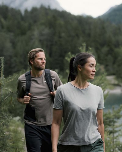 Wellness und Luxus: Ihr Hotel in Tirol Zwei Wanderer auf einem Pfad nahe einem Bergsee umgeben von Wald