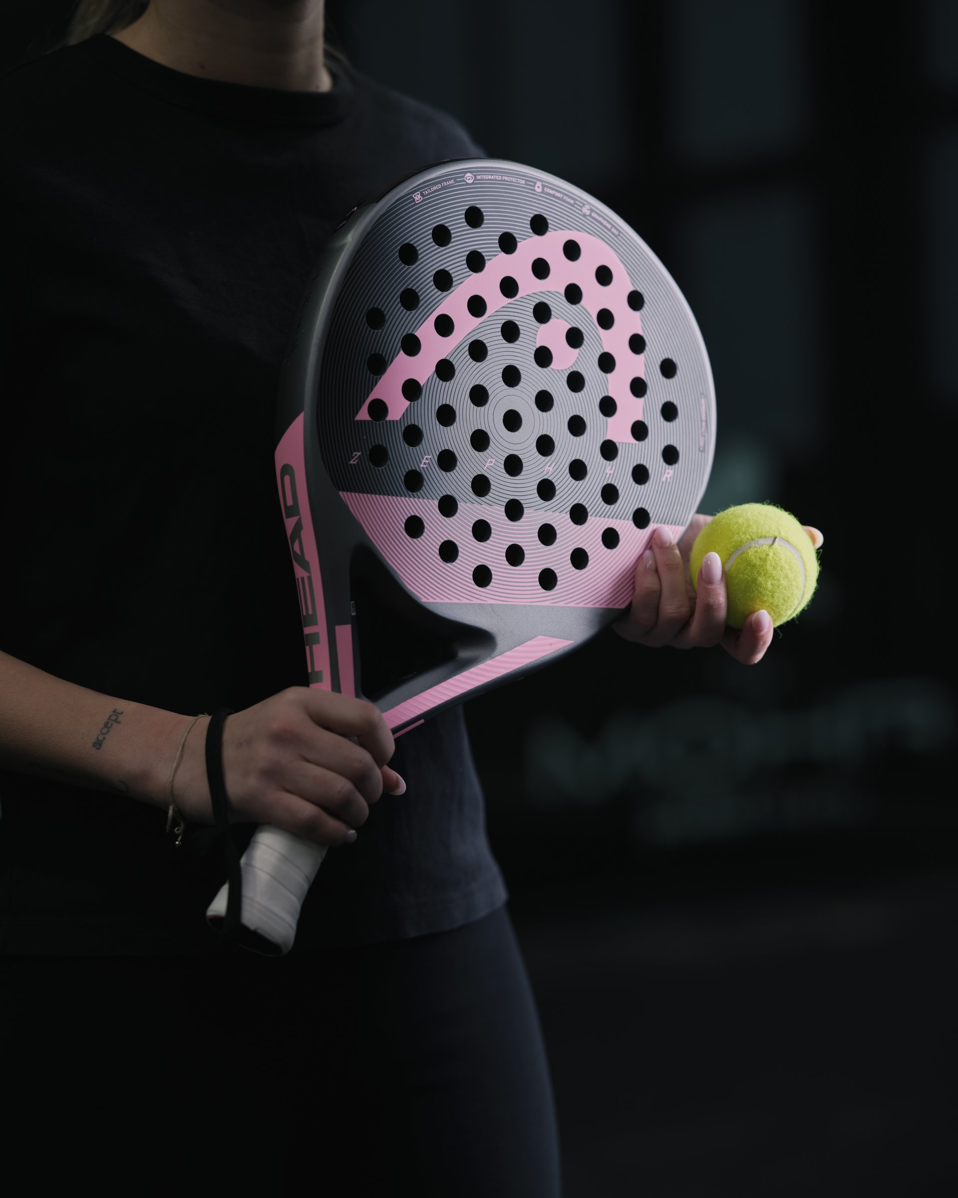 Wellness und Luxus: Ihr Hotel in Tirol Person mit rosafarbenem Padel-Schläger und gelbem Ball