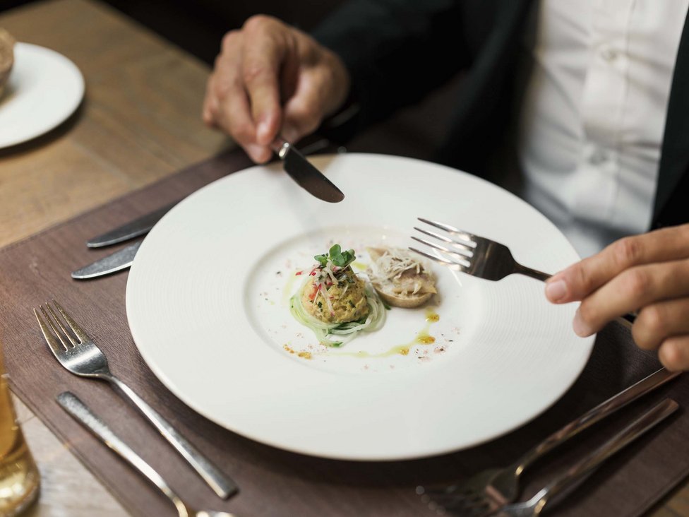 MOHR Genuss im Sporthotel in Österreich Fein angerichtete Vorspeise auf weißem Teller in gehobenem Restaurant