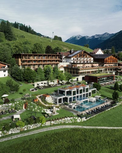 Ihr Favorit? MOHR life resort – das Hotel in Lermoos Hotelanlage mit Pool in grüner Berglandschaft