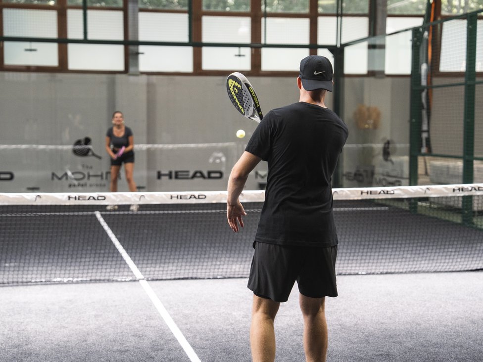 Wellness und Luxus: Ihr Hotel in Tirol Zwei Personen spielen Padel-Tennis auf einem Indoor-Platz
