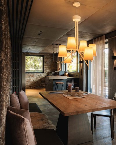 Wellness und Luxus: Ihr Hotel in Tirol Modernes Esszimmer mit Holztisch und großen Fenstern mit Blick auf die Berge