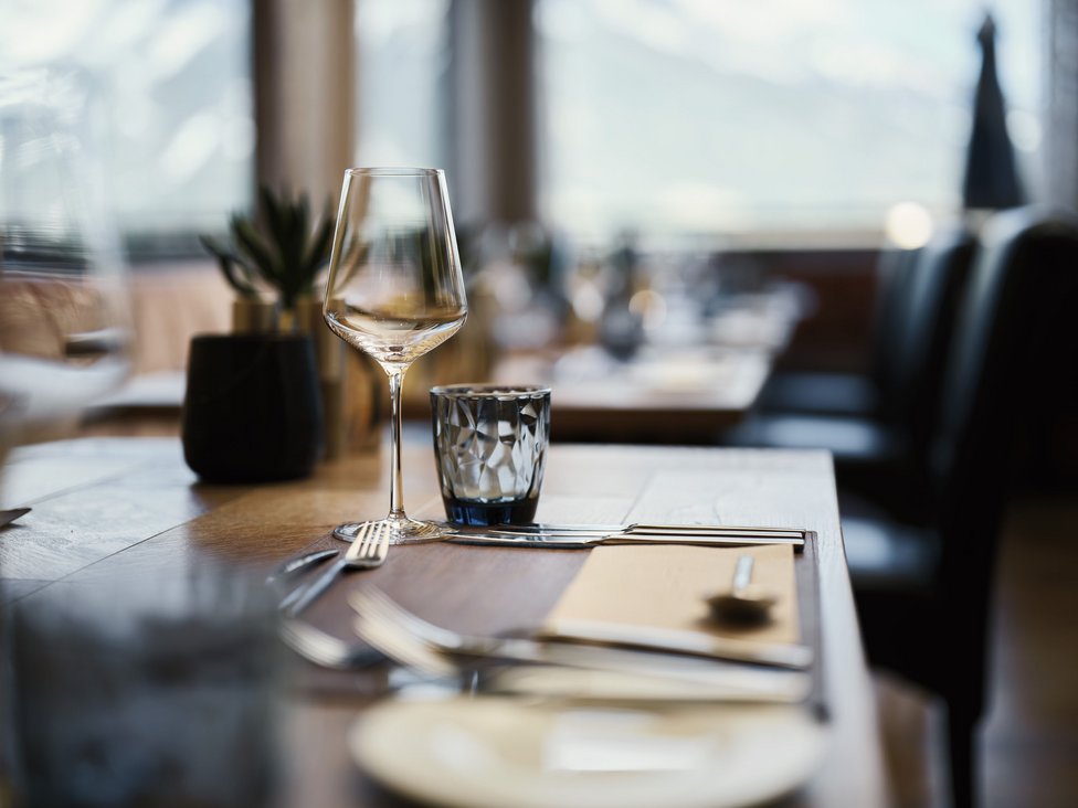 Wellness und Luxus: Ihr Hotel in Tirol Eleganter gedeckter Tisch mit Weinglas und Besteck im Restaurant