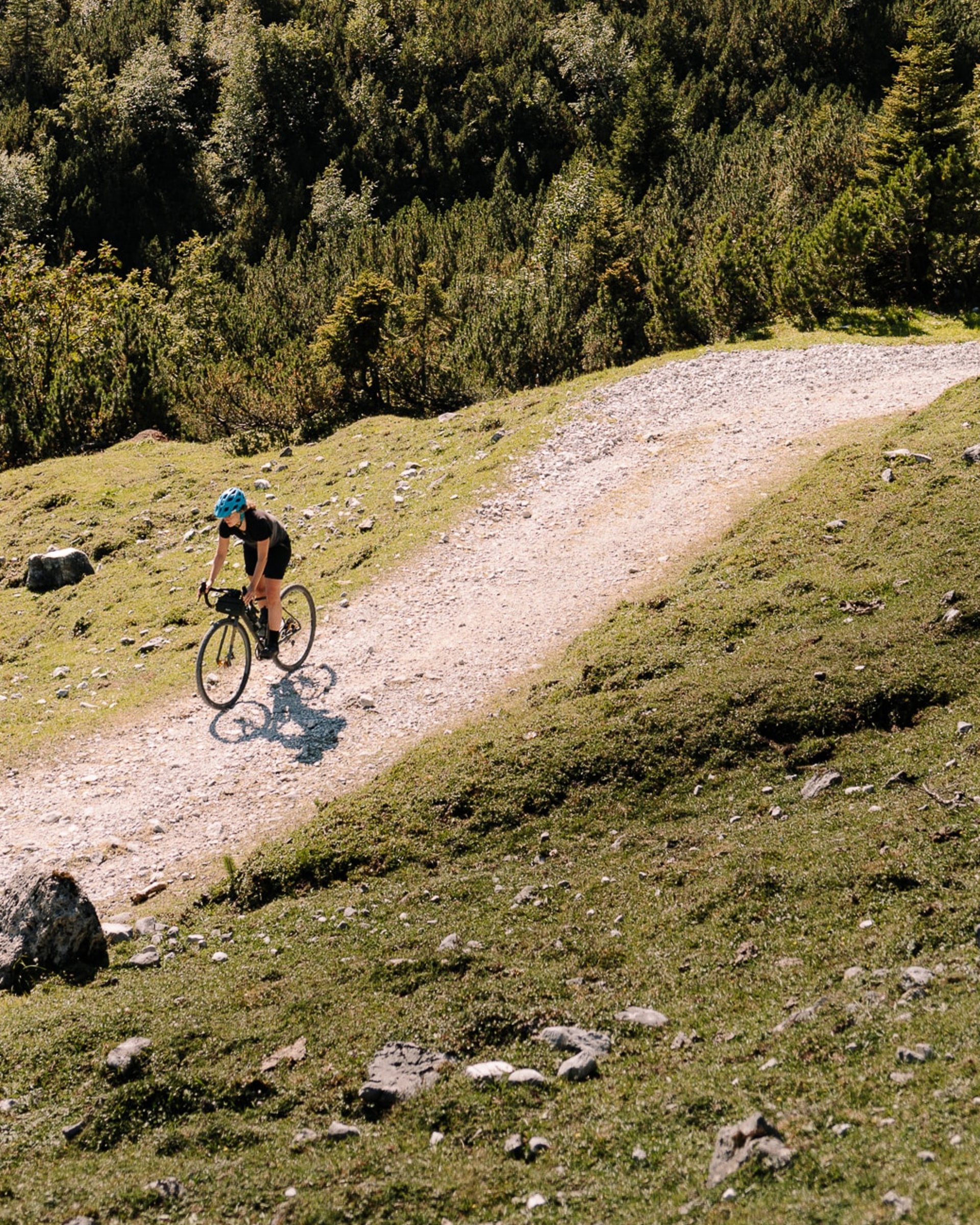 Hoch hinaus beim MTB-Urlaub in Tirol Radfahrer auf einem bergigen Wanderweg mit Tannenbäumen und Felsen