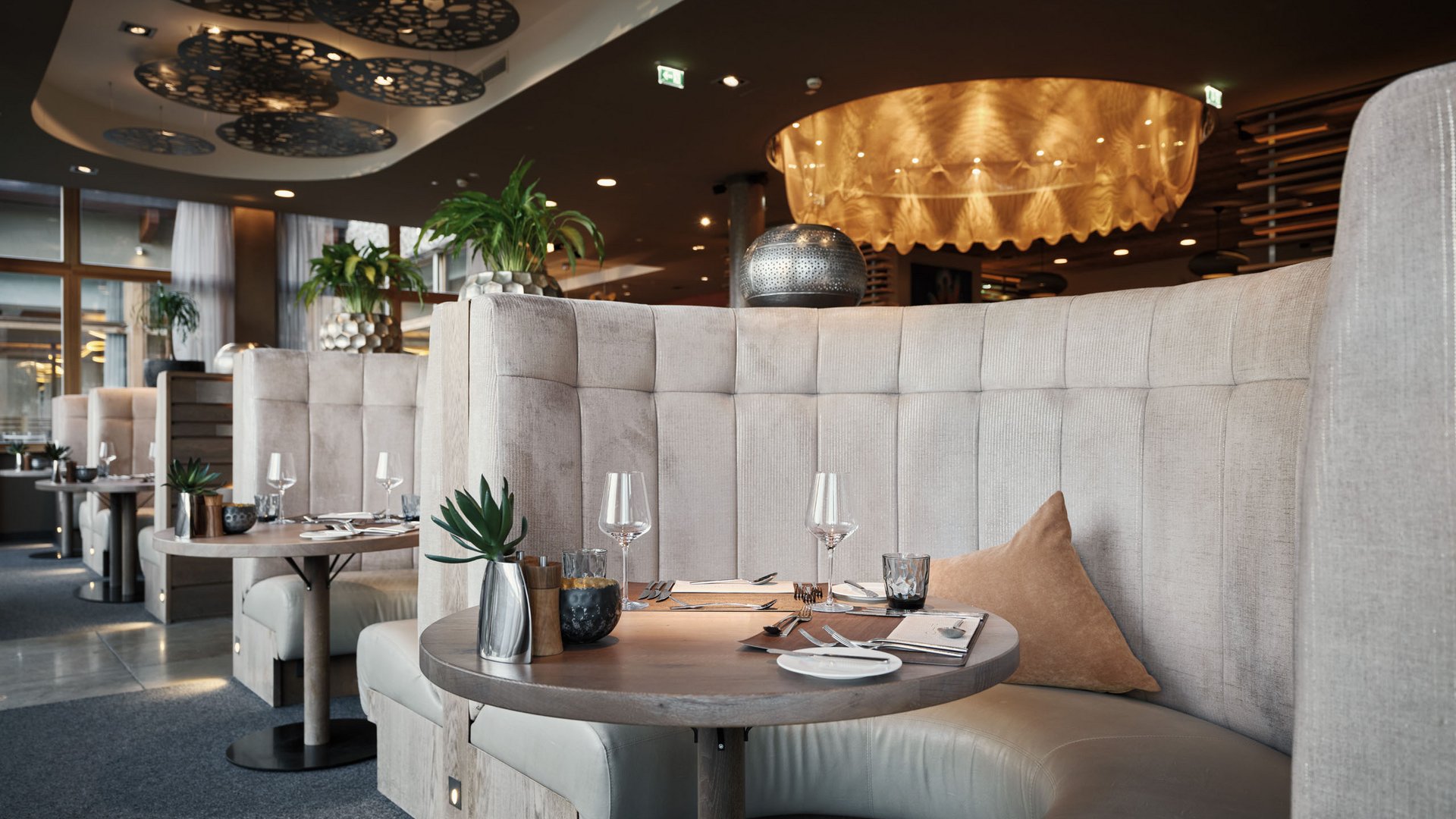 MOHR life resort Bildergalerie Gemütliche runde Sitzgruppe in einem modernen Restaurant mit gedecktem Tisch