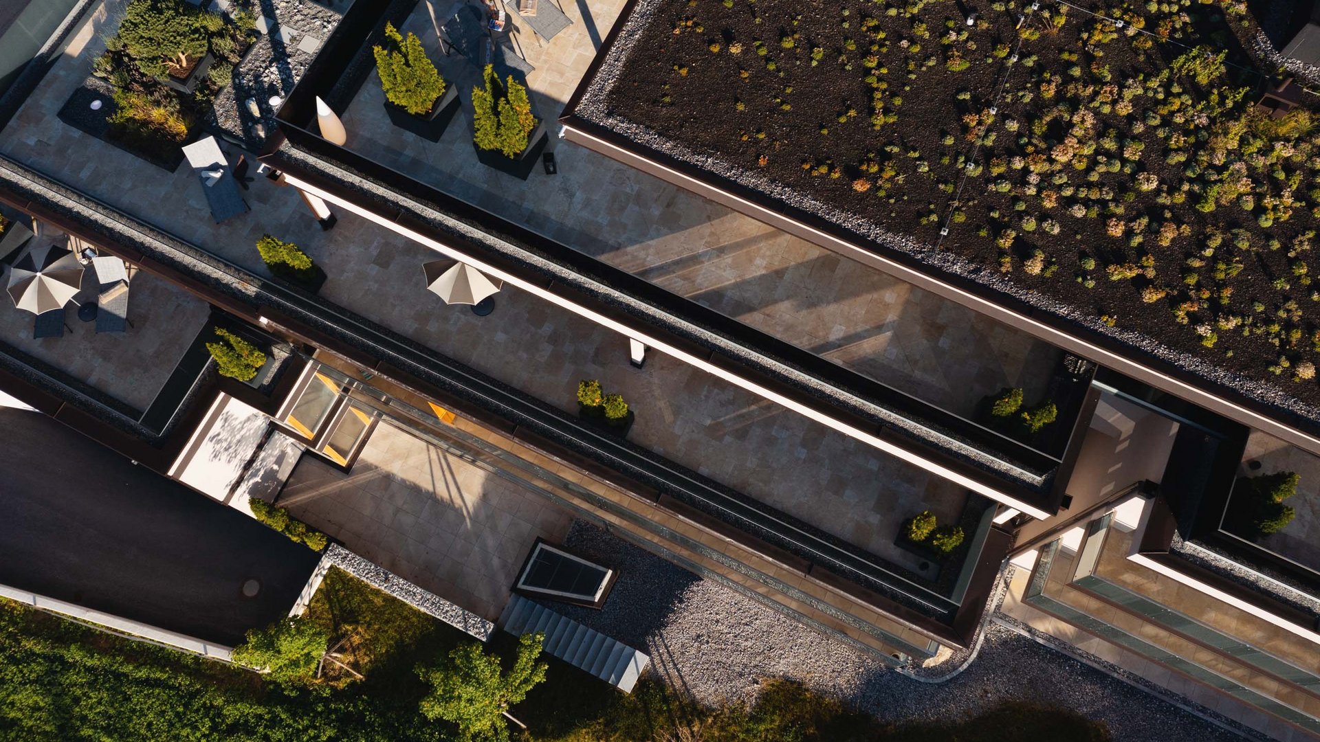Ihr Favorit? MOHR life resort – das Hotel in Lermoos Drohnenaufnahme eines modernen Gebäudes mit begrüntem Dach und Terrasse