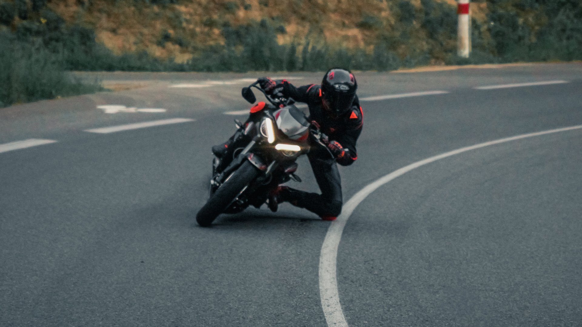 Zahlreiche Ausflugsziele rund um Lermoos Motorradfahrer fährt kurvenreich auf Bergstraße bei Dämmerung