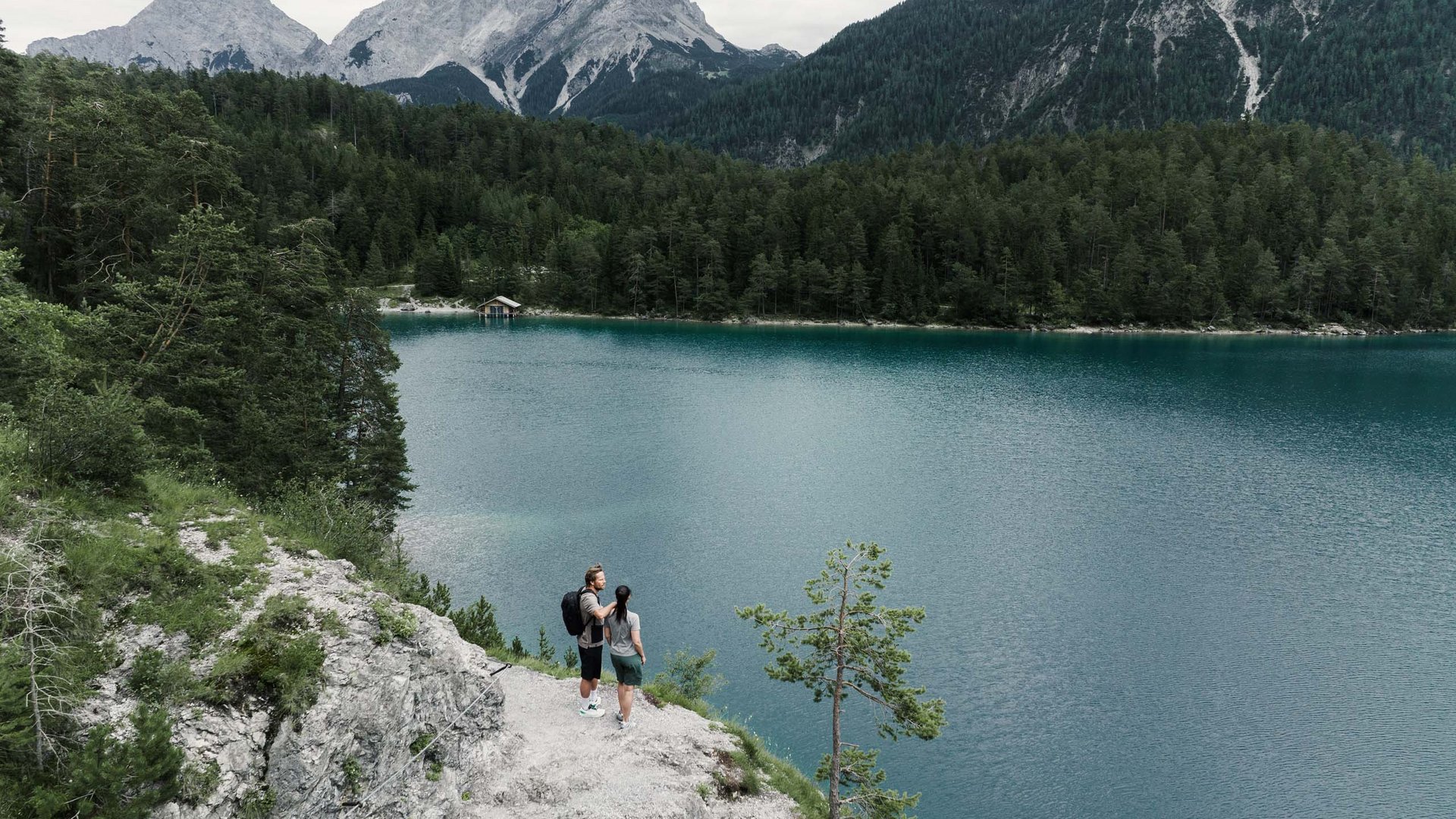 MOHR life resort Bildergalerie Wanderer auf Felsen mit Blick auf See und Berge im Hintergrund