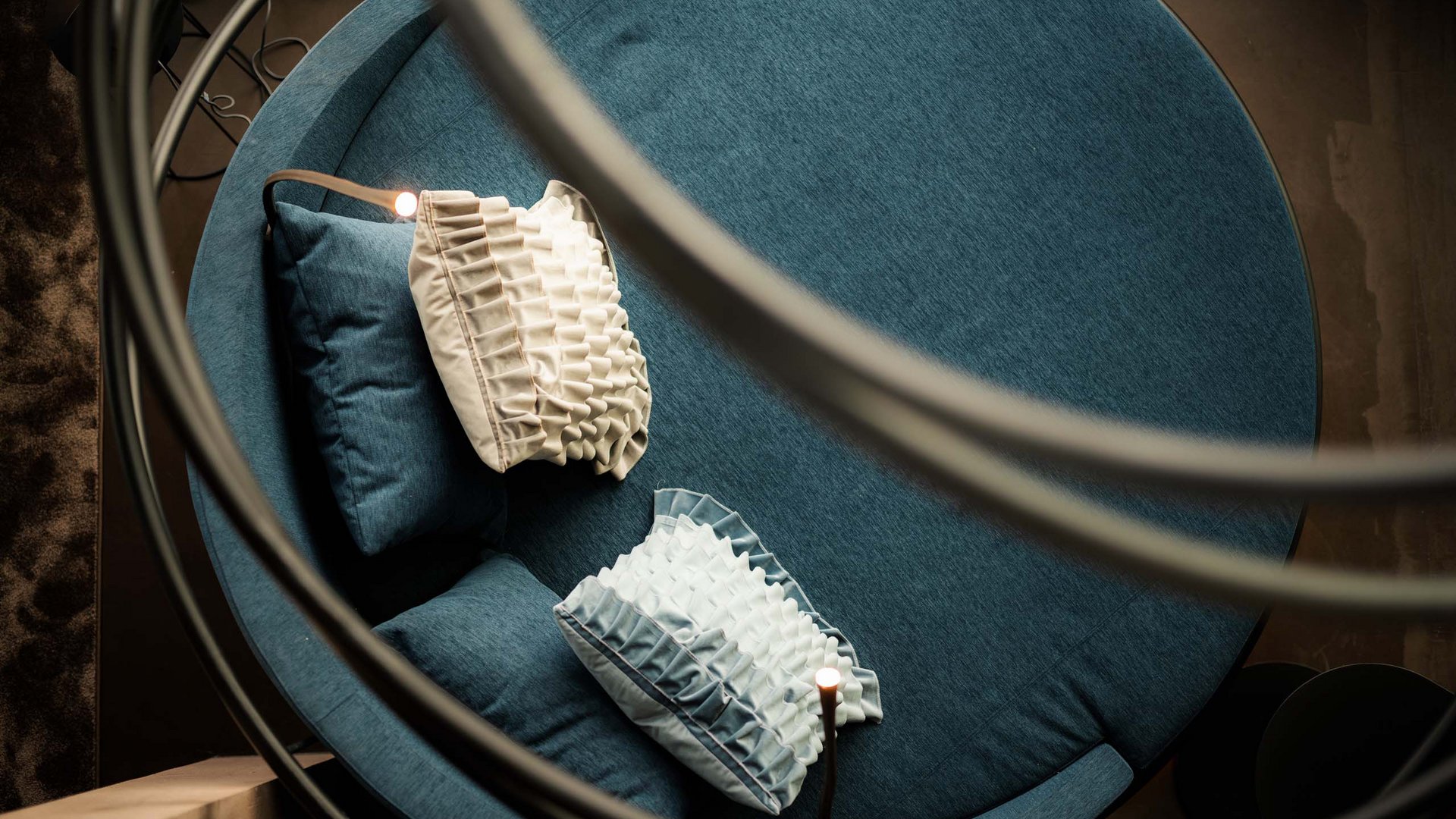 MOHR life resort Bildergalerie Rundes blaues Sofa mit dekorativen Kissen von oben fotografiert