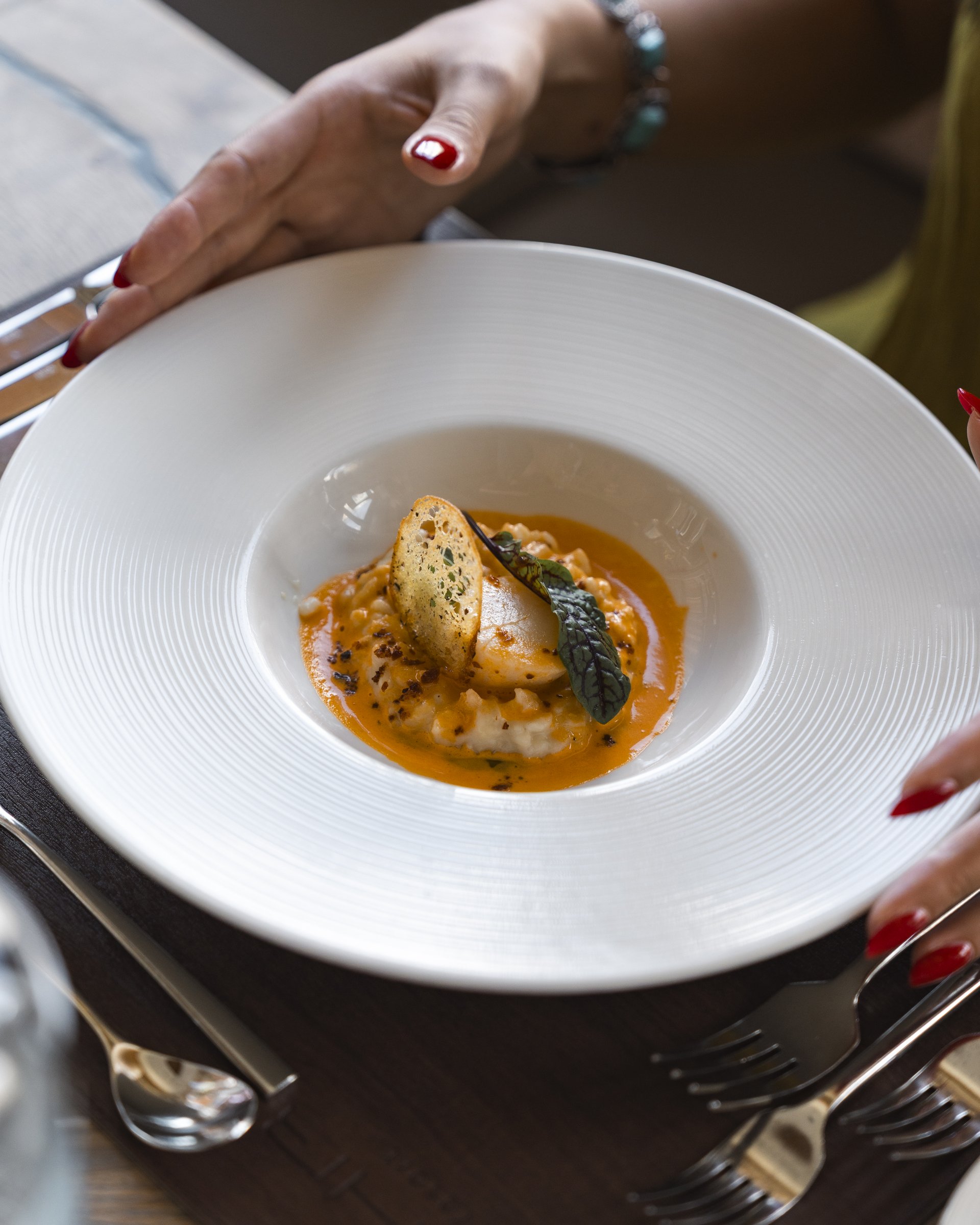 Wellness und Luxus: Ihr Hotel in Tirol Gourmetgericht mit Sauce, Gemüse und knuspriger Beilage auf weißem Teller