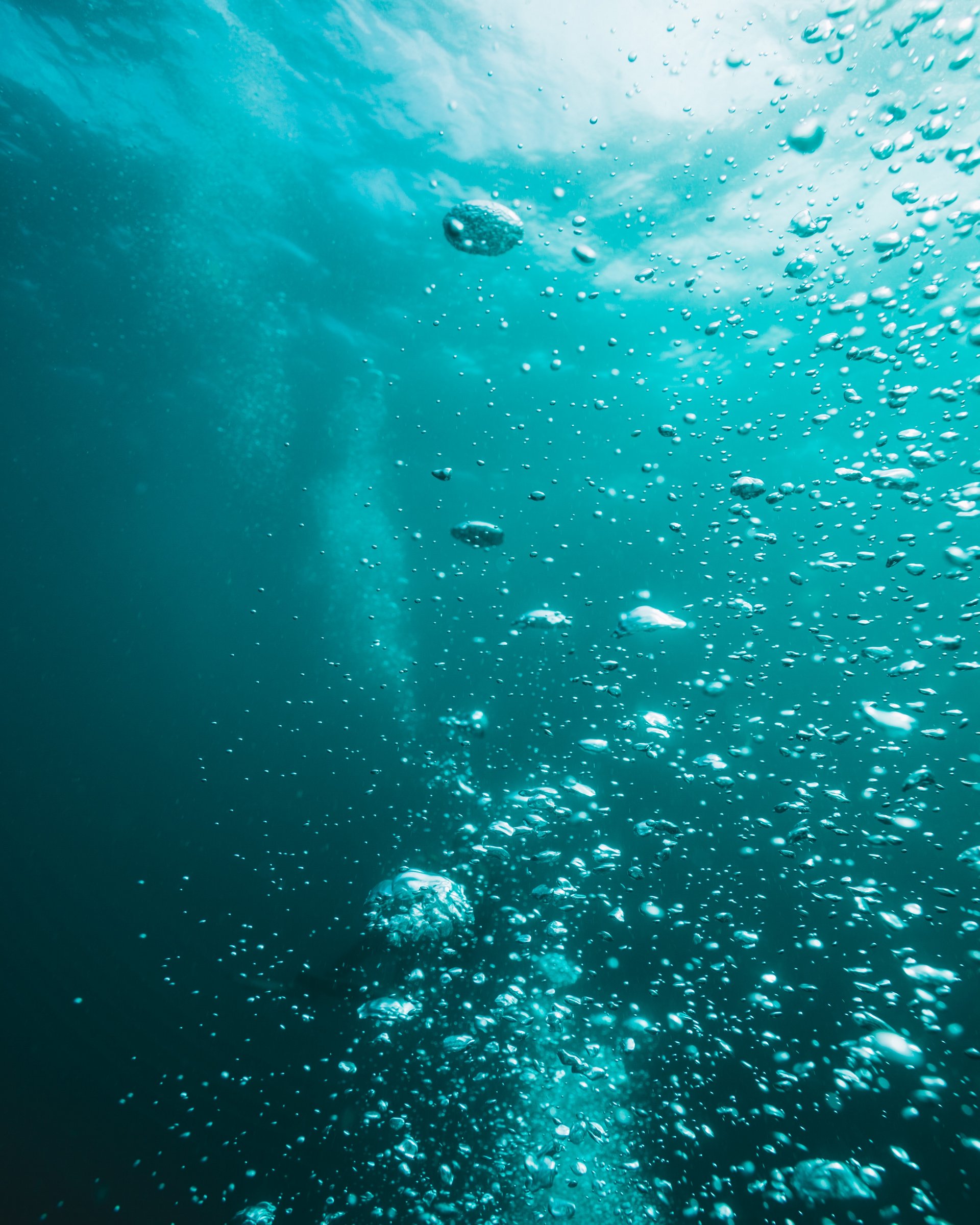 Ein einmaliges Angebot – eistauchen im Blindsee Unterwasseraufnahme mit aufsteigenden Luftblasen im blauen Wasser