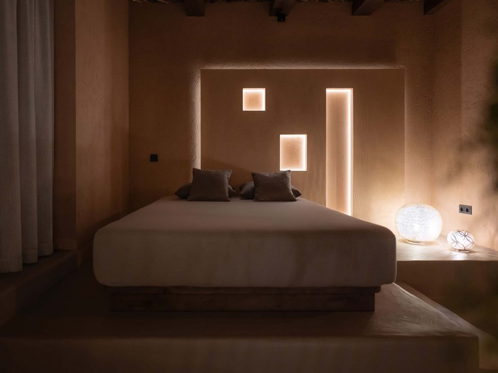 Großzügig und exklusiv: Ihr Wellnessurlaub in Tirol Schlichtes Schlafzimmer mit indirekter Wandbeleuchtung und zwei Lampen