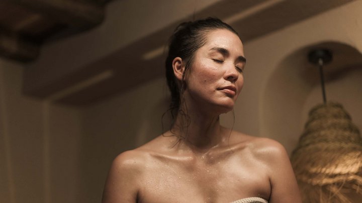 Wellness und Luxus: Ihr Hotel in Tirol Frau entspannt mit geschlossenen Augen nach dem Duschen