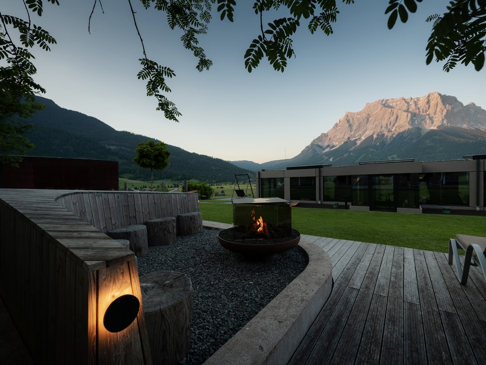 Wellness und Luxus: Ihr Hotel in Tirol Feuerstelle mit Sitzbereich und Bergblick bei Sonnenuntergang