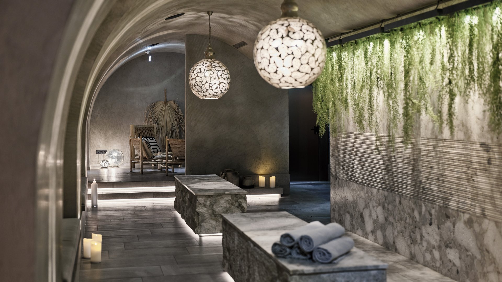 Großzügig und exklusiv: Ihr Wellnessurlaub in Tirol Moderner Spa mit beleuchteten Steintischen und grünen Pflanzen an der Wand