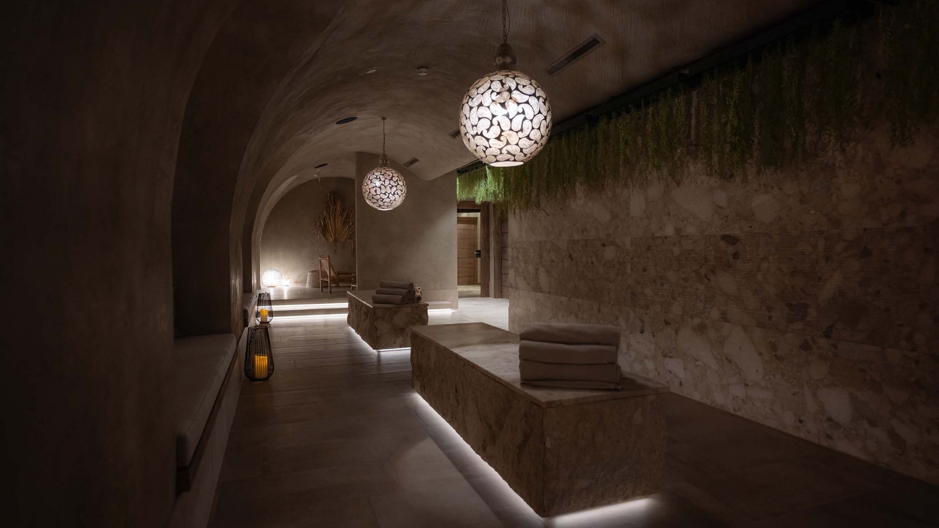 MOHR life resort Bildergalerie Dunkler Spa-Ruheraum mit modernen Lampen und aufgestapelten Handtüchern