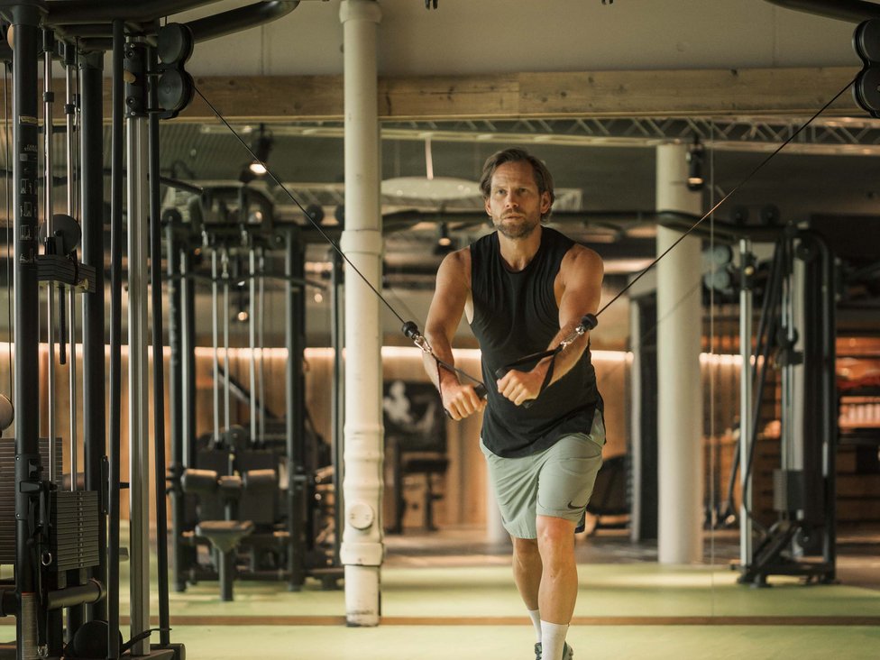 MOHR intensity: Sporturlaub in Österreich Mann trainiert mit Kabelzug in modernem Fitnessstudio