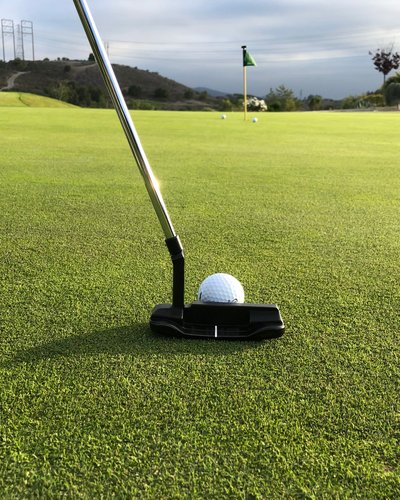 Ihr Golfhotel in Tirol – MOHR life resort Golfball auf Grün mit Putter und Fahne im Hintergrund