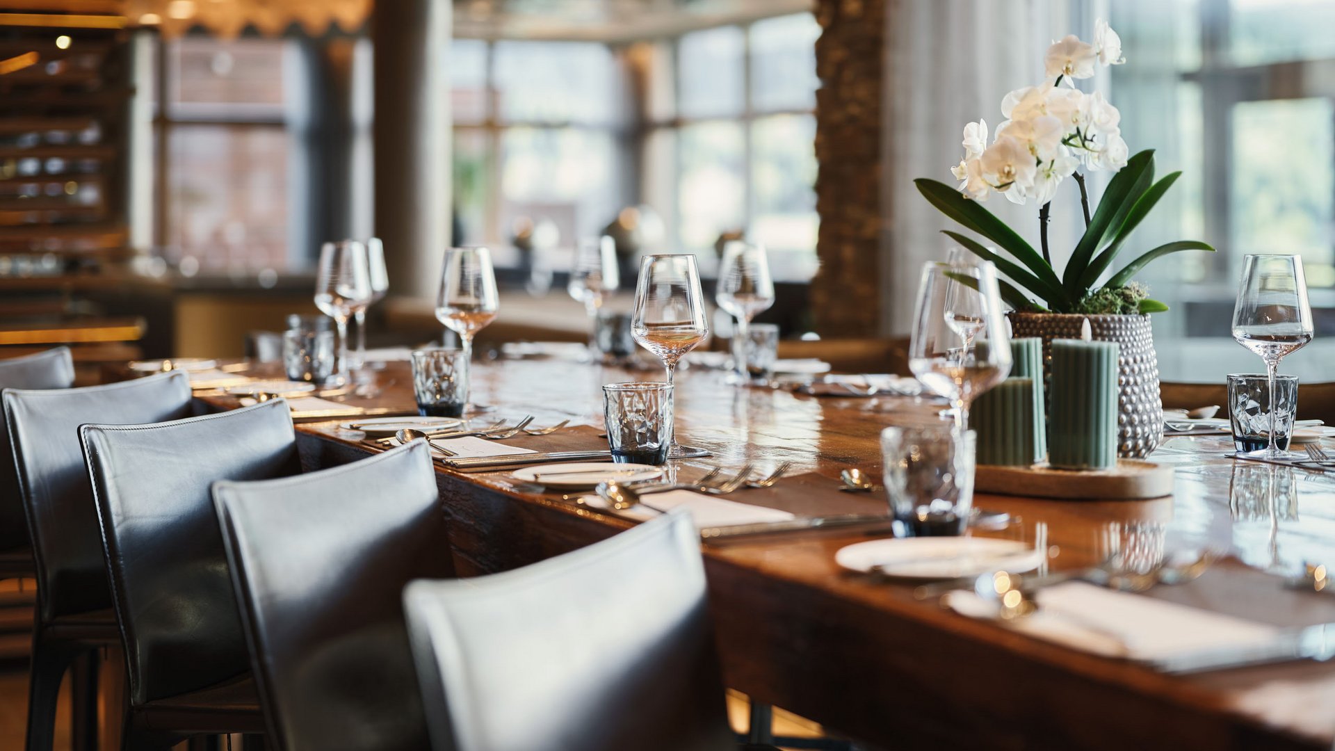 MOHR life resort Bildergalerie Eleganter Esstisch in modernem Restaurant mit Gläsern und Blumen