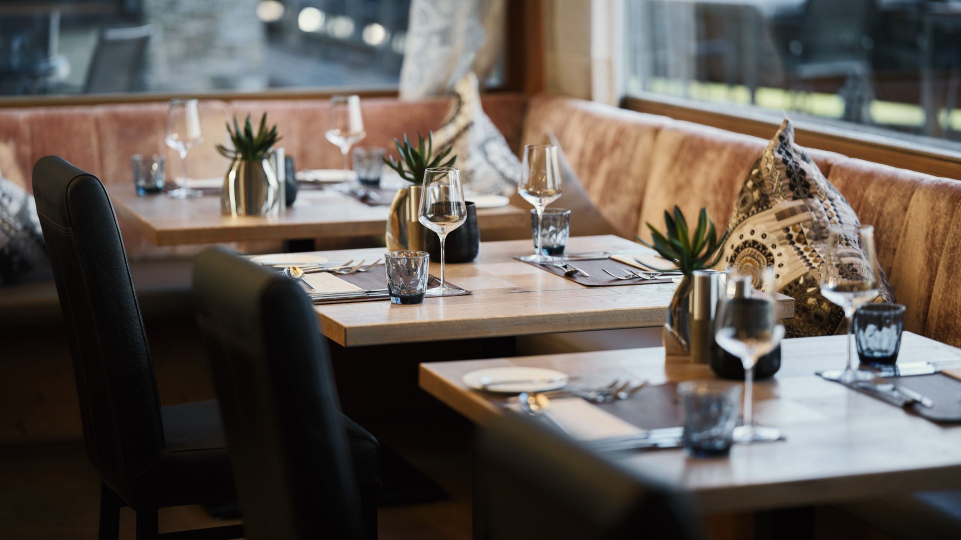 MOHR life resort Bildergalerie Eleganter eingedeckter Restaurantbereich mit Holztischen und Ledersesseln