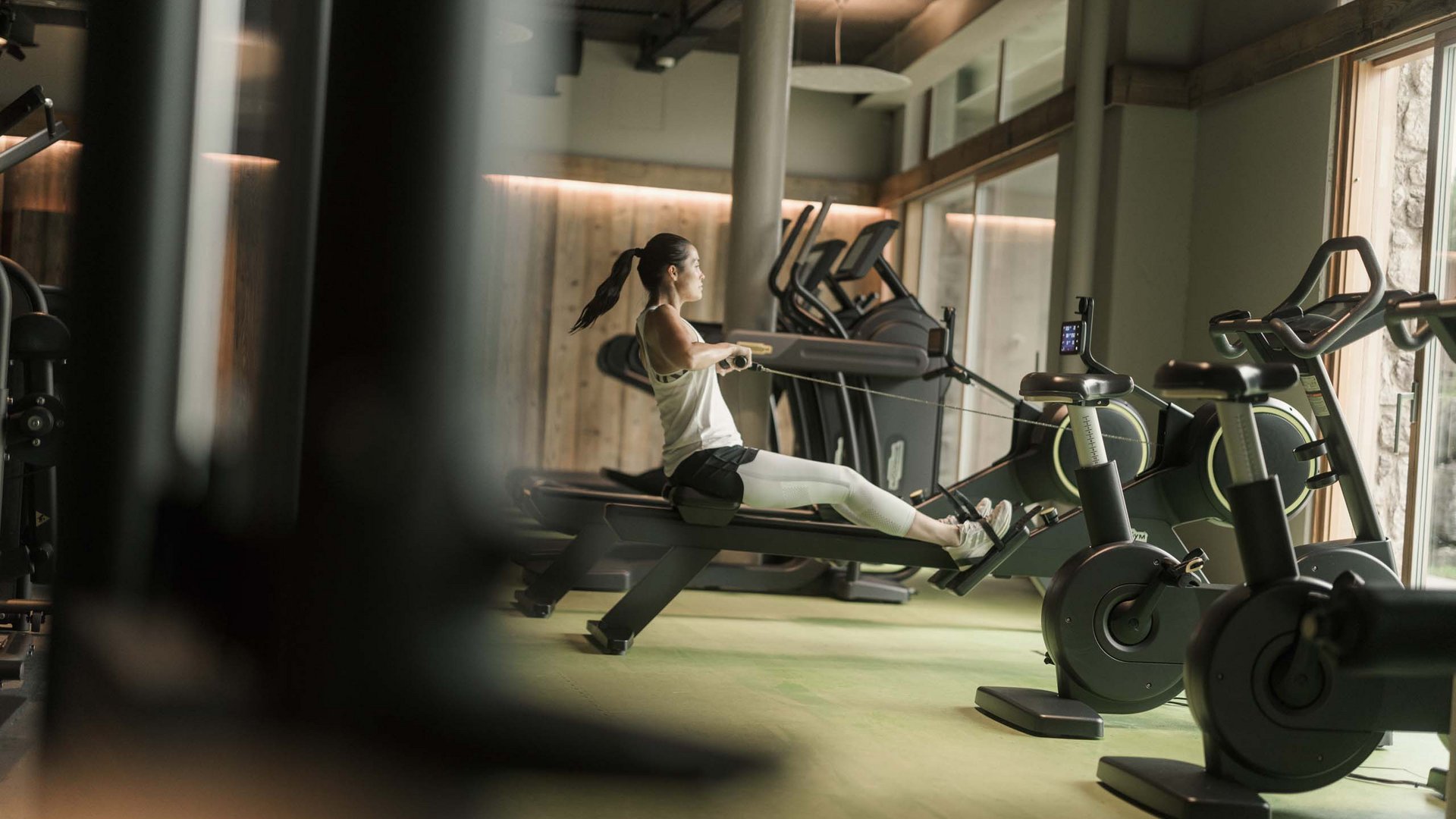 MOHR life resort Bildergalerie Frau trainiert auf dem Rudergerät im modernen Fitnessstudio