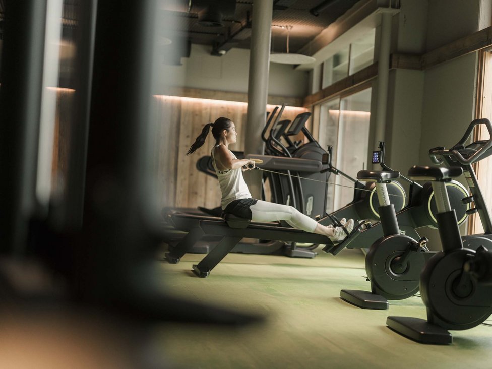MOHR intensity: Sporturlaub in Österreich Frau trainiert auf dem Rudergerät im modernen Fitnessstudio