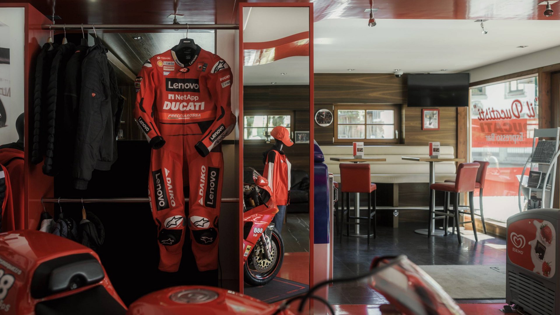 MOHR life resort Bildergalerie Rotes Ducati-Rennanzug und Motorrad in einem Café mit Sitzbereich