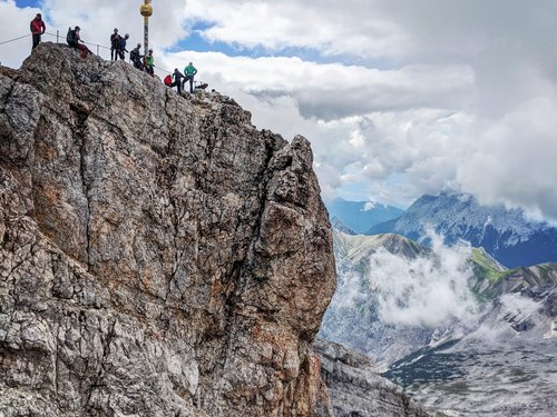 Sehenswürdigkeiten rund um Lermoos Berggipfel mit Wanderern und Gipfelkreuz unter bewölktem Himmel