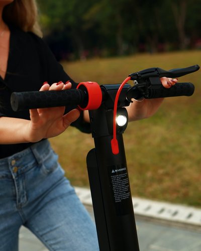 Wellness und Luxus: Ihr Hotel in Tirol Frau hält Lenker eines E-Scooters im Park