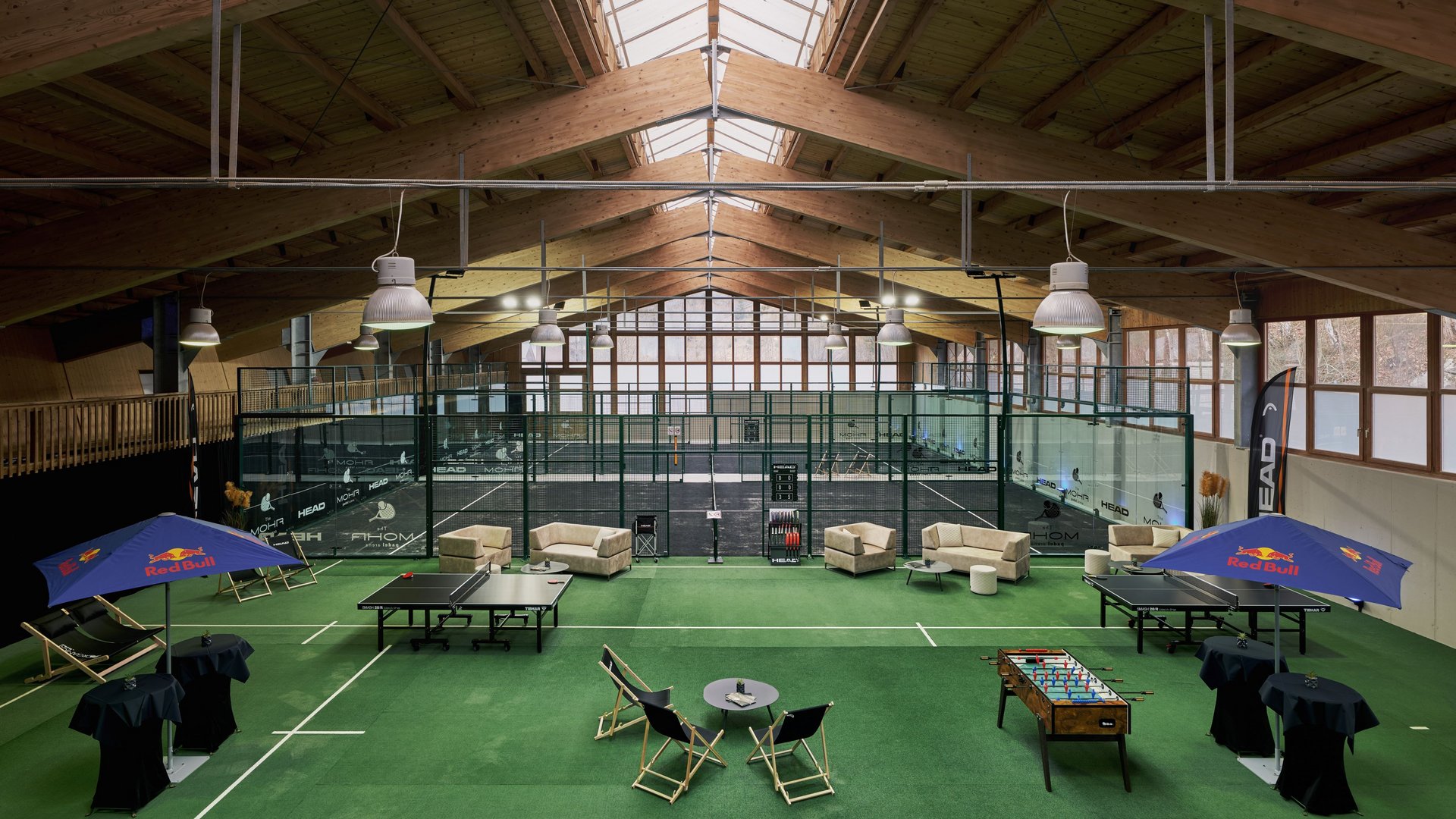 Endlich Indoor Padel spielen in Lermoos in Tirol. Im MOHR life resort Indoor-Padel-Tennisplätze mit Spielern und Sitzbereich auf grünem Teppich