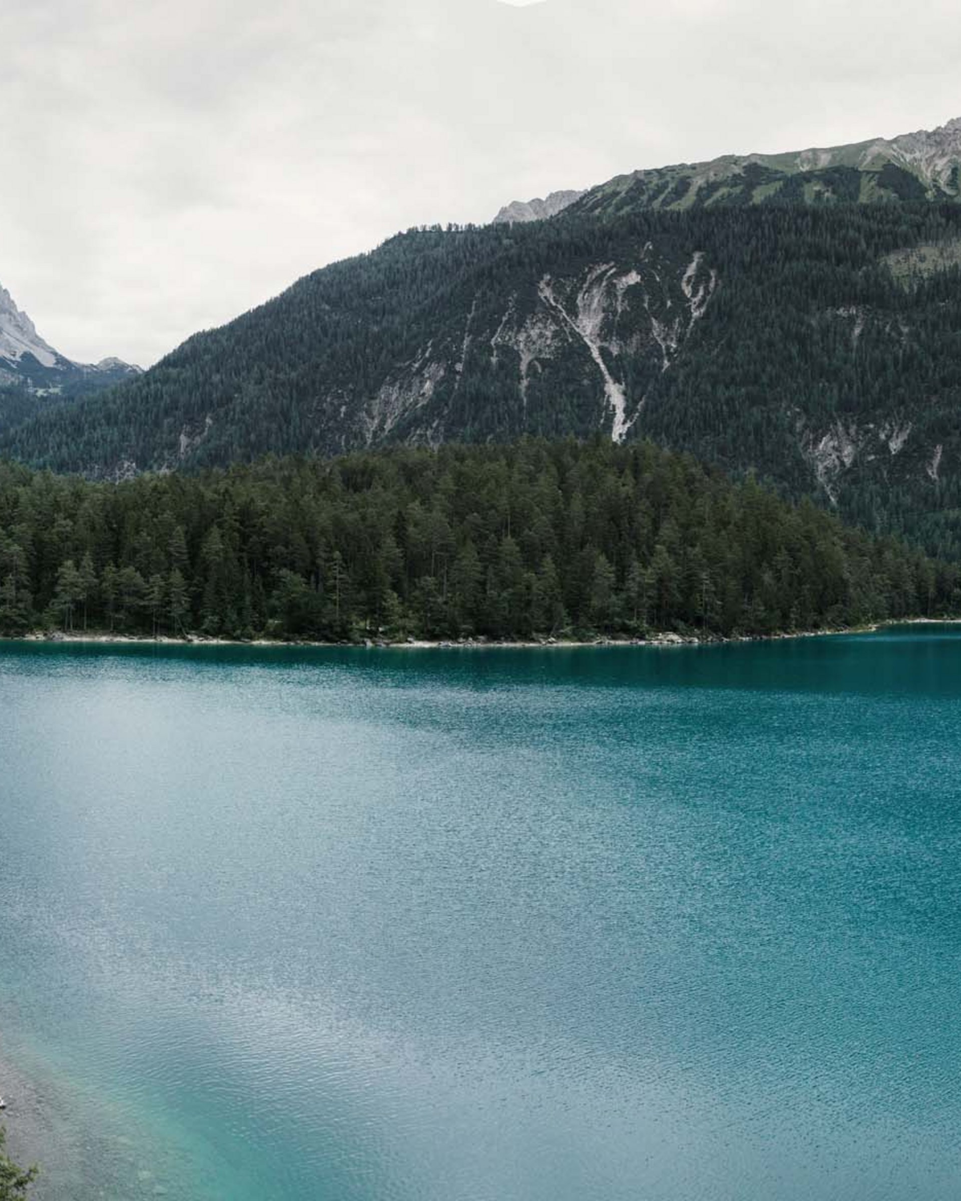 Wandern in und rund um Lermoos Zwei Wanderer stehen auf einer Klippe über einem blauen Bergsee
